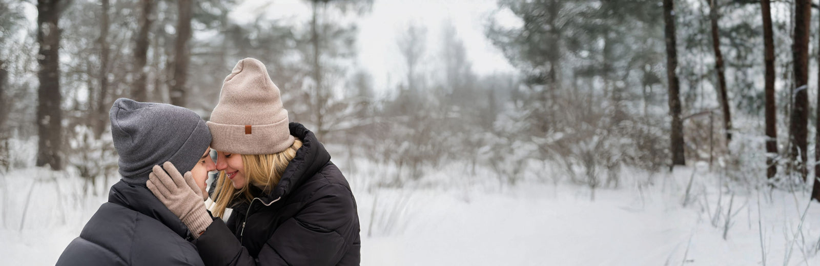 Two people hugging in a snowy forest