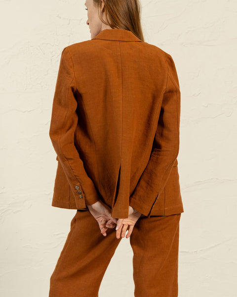 Rust-colored linen blazer Quin shown from back view with tailored fit and classic vent detail by menique