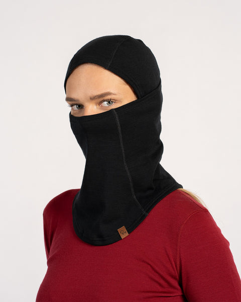 Woman wearing a black Merino wool unisex balaclava covering head, nose, and mouth with a red top.