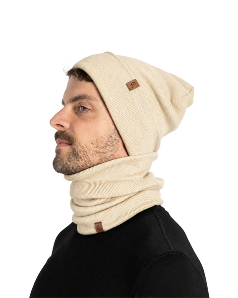 Profile view of a man in a black shirt wearing a beige beanie and a matching beige neck gaiter around his neck.