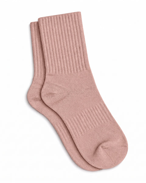 A pair of dusty pink, ribbed crew socks lying flat against a plain white background.