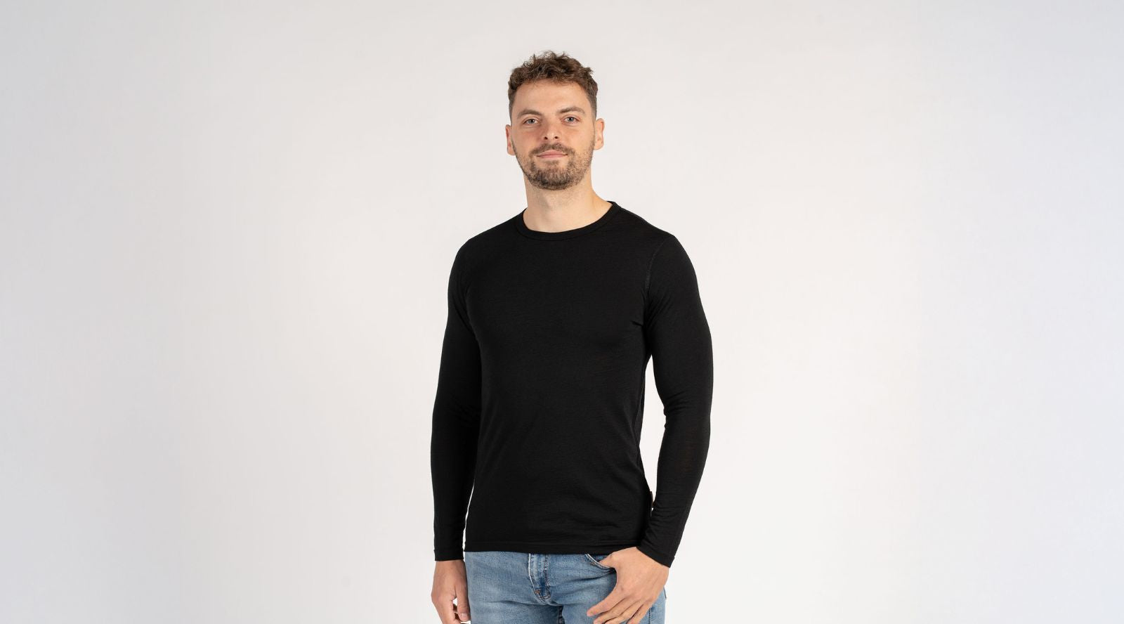 Man sitting on the sofa and wearing Merino wool long sleeve top