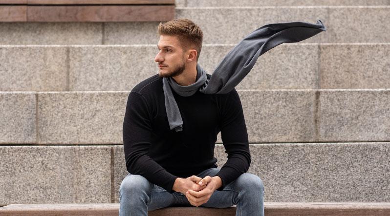 Man sitting outside and wearing Merino wool scarf