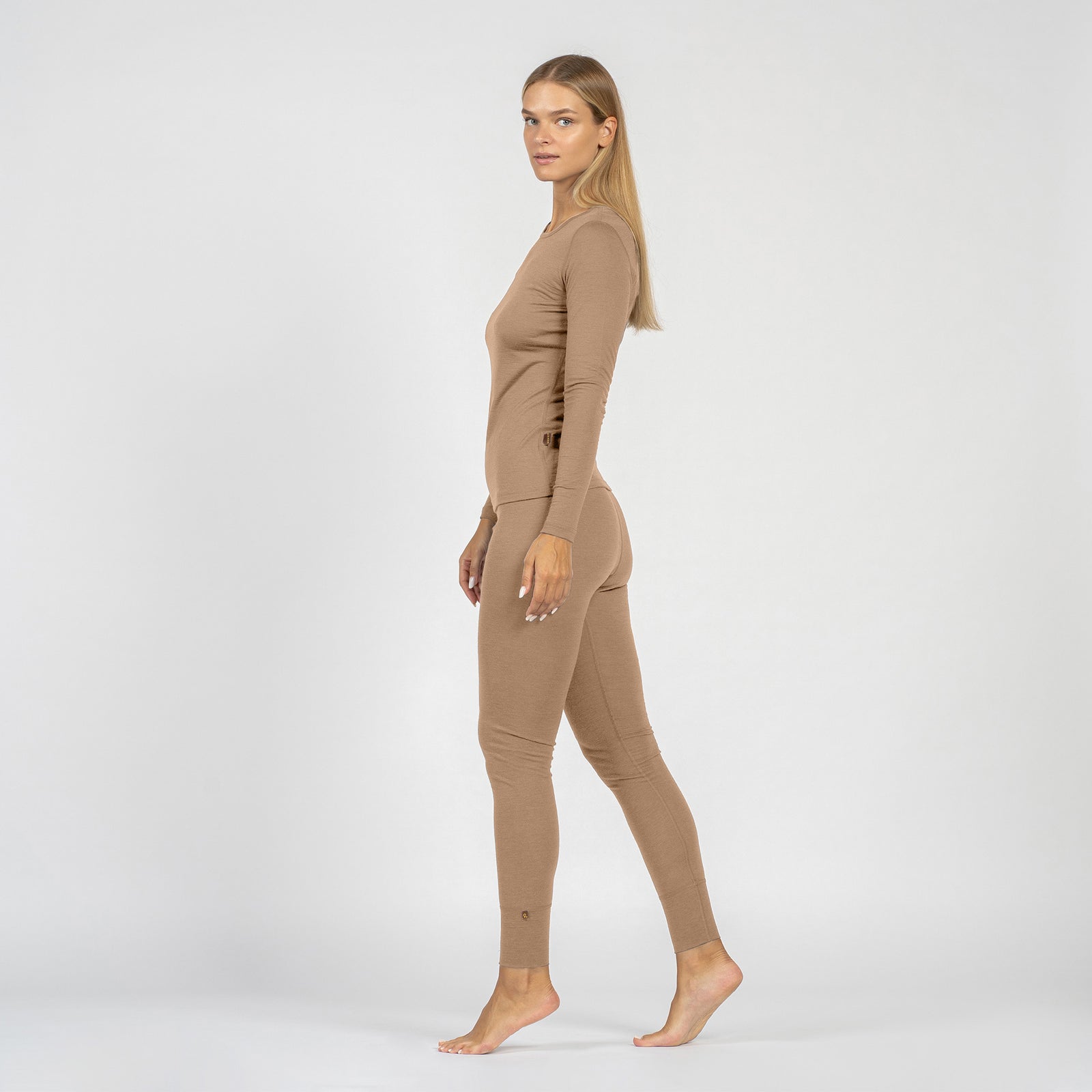 Woman wearing a beige merino wool leggings on a white background
