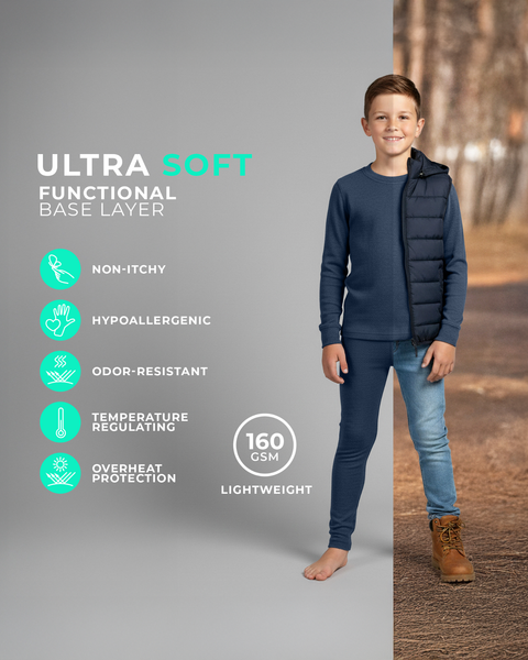 A boy wearing a denim-blue long-sleeve base layer set, shown barefoot against a split studio and outdoor background featuring icons for non-itchy, hypoallergenic, odor-resistant, temperature-regulating, and lightweight 160 GSM fabric.