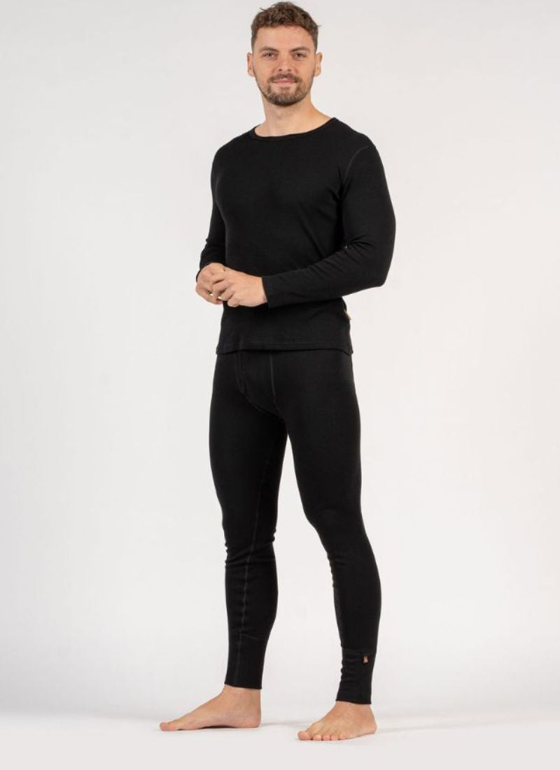 Man wearing black long-sleeve shirt and black leggings on a white background