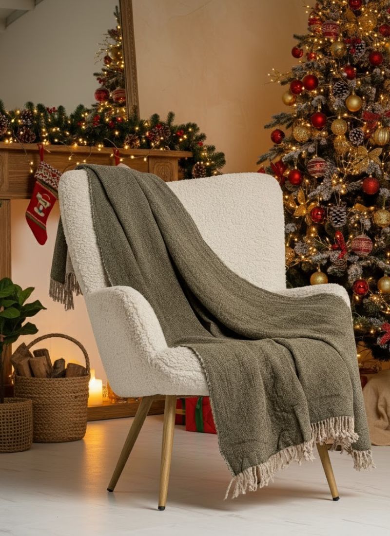 Cozy chair with a green blanket in a festive room with Christmas trees and decorations.