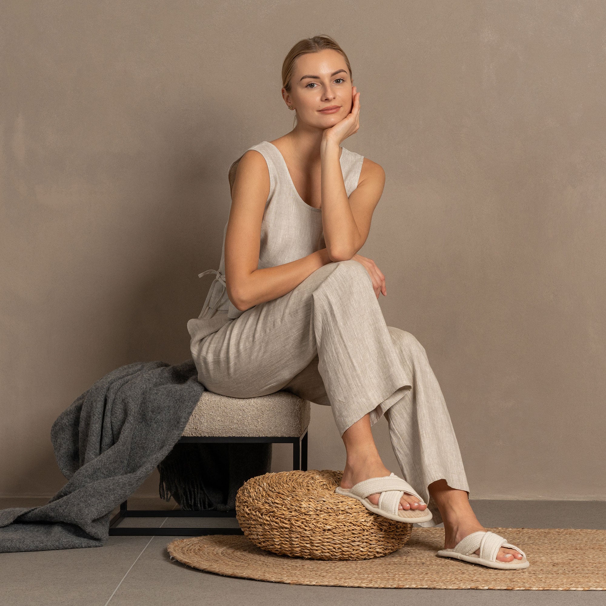 Close up of a woman wearing linen pants and linen & merino wool cross slippers.