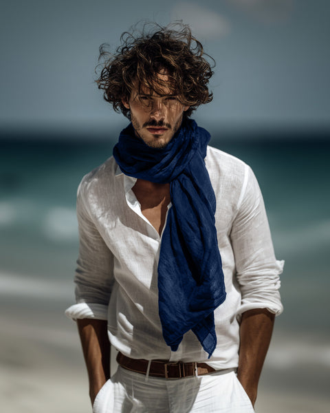 Man wearing a white shirt and blue scarf on a beach