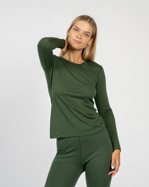 The menique women&#39;s merino wool dark green long sleeve top matched with menique dark green bottoms, from the front.