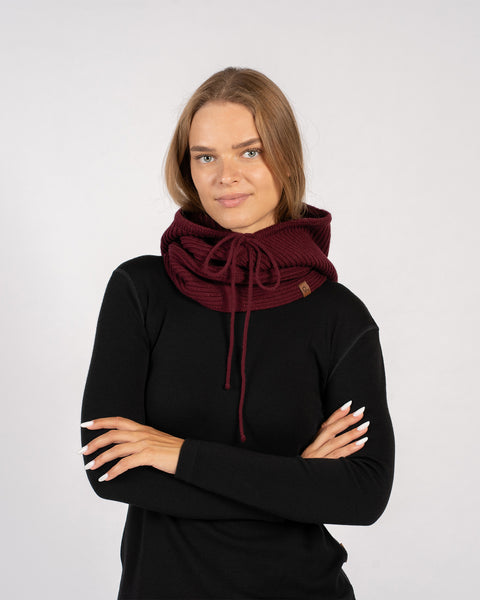 Woman posing with arms crossed, wearing a royal cherry knitted merino wool hood balaclava styled as a neck warmer.