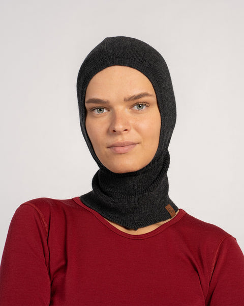 Woman facing front in a dark gray knitted Merino wool balaclava, full head and neck coverage.