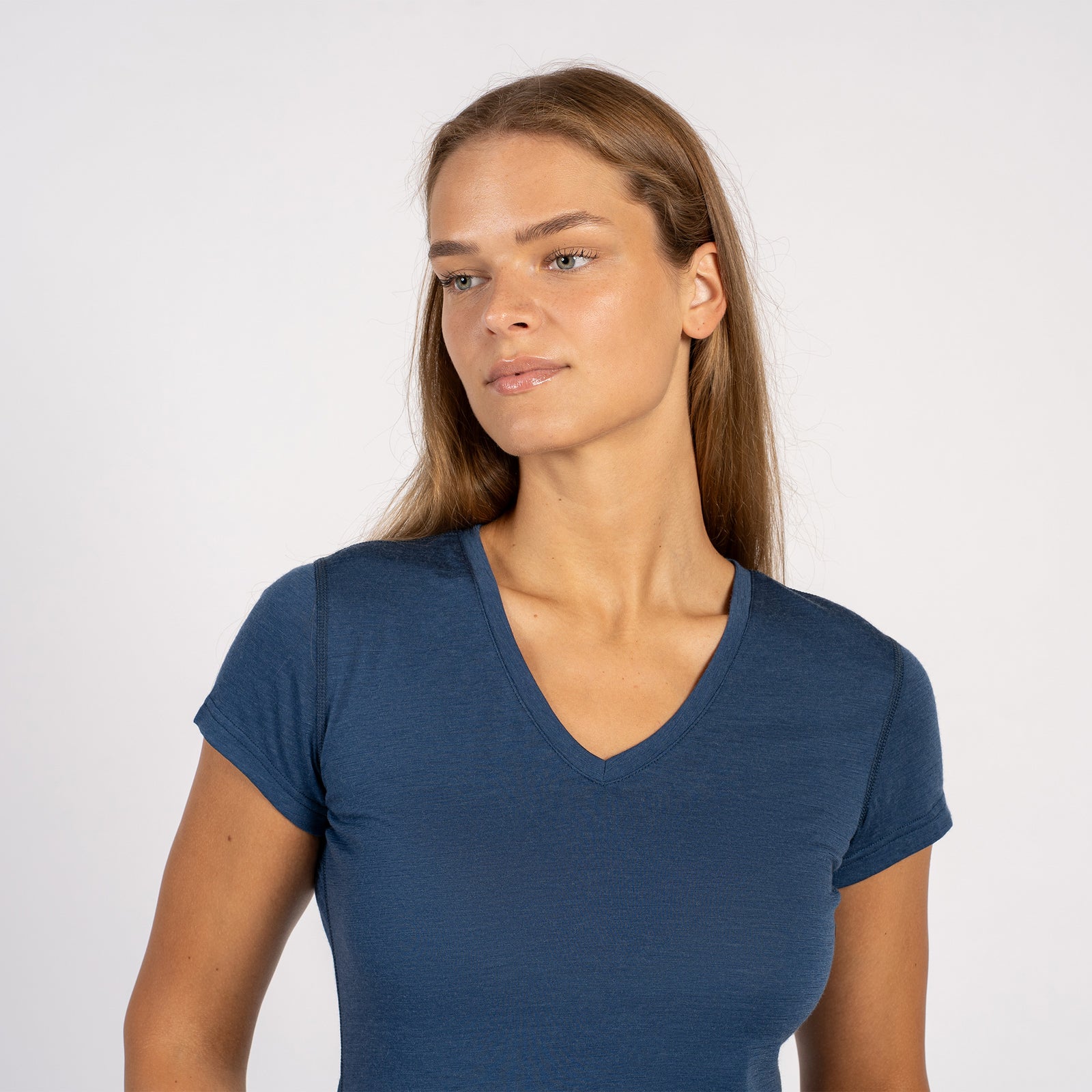 Woman smiling in a denim blue Merino wool V-neck short sleeve T-shirt.