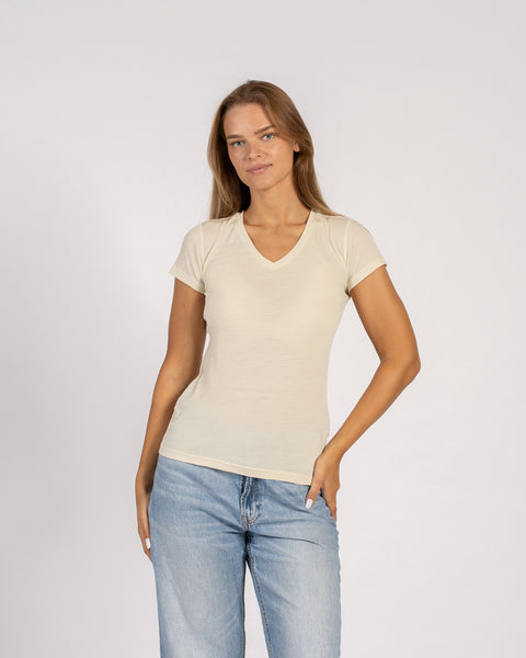 Woman wearing a natural-colored Merino wool V-neck T-shirt with short sleeves.
