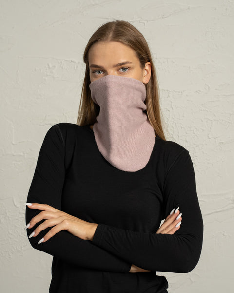 Woman wearing dusty pink knit Merino wool bandana neck gaiter covering face.