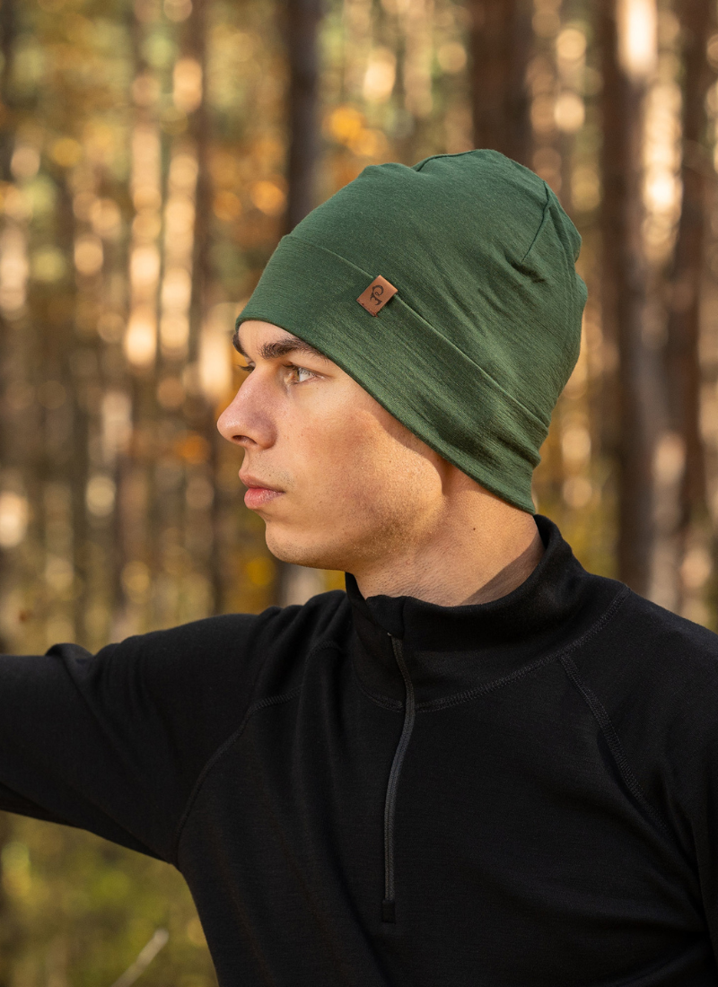 Man outdoors wearing dark green merino wool beanie