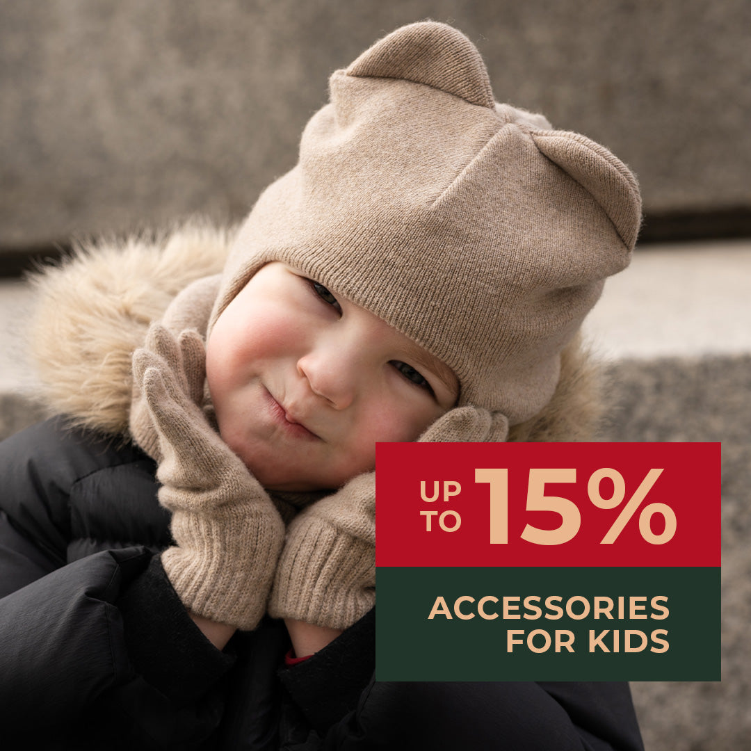 Small girl wearing cute Merino wool balaclava with ears and gloves in creamy beige color. Accessories for kids up to 15% of on black Friday sale.