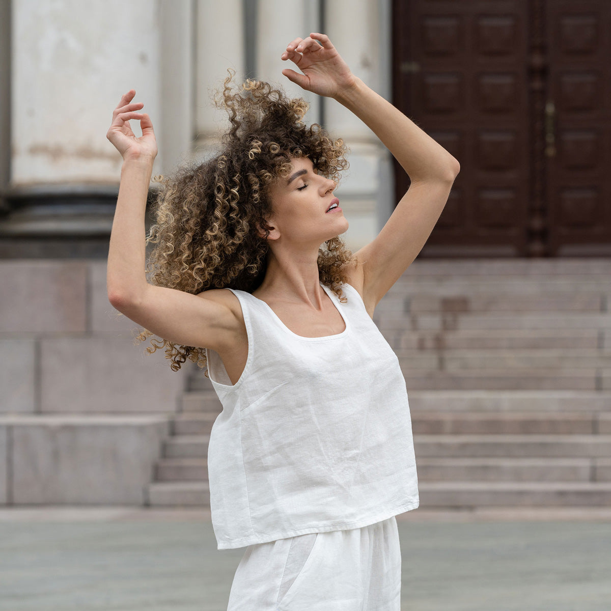 Woman standing outdoor and wearing Linen Sleeveless Crop Top Ana in Pure White color