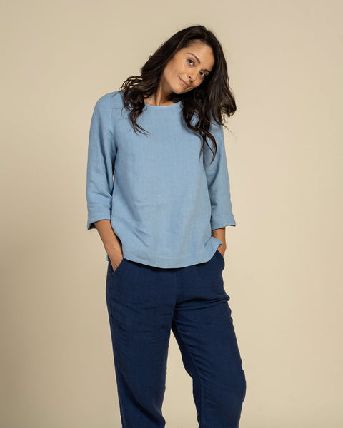 Woman wearing linen blouse in cloudy blue color front 